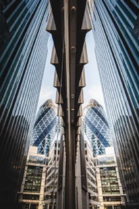 Photo du bâtiment Le Cornichon à Londres qui se reflète dans une vitrine en symétrie