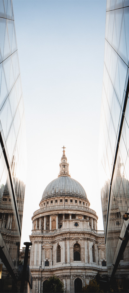 Photographie d'architecture de Saint Paul à Londres se reflétant dans les vitres d'un immeuble