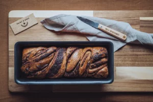 Babka au chocolat dans son moule, à côté d'un couteau