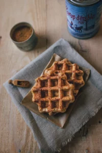 Photo de deux gaufres à côté d'un pot de cannelle et d'une boîte de sirop d'érable