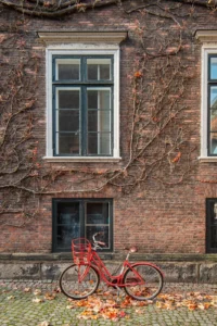 Photo d'un vélo rouge devant une façade en briques à Copenhague